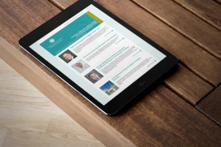 A tablet showing the LCN email newsletter on a wood floor.